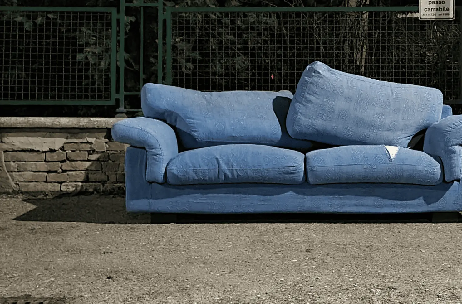 Sofa discarded on sidewalk for pickup